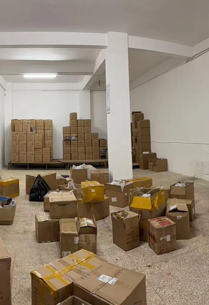 Qili Toys mixed-SKU consolidation warehouse in Shenzhen — open cartons from different product lines staged for buyer-confirmed packing list, with sealed wholesale cartons on pallets at the back